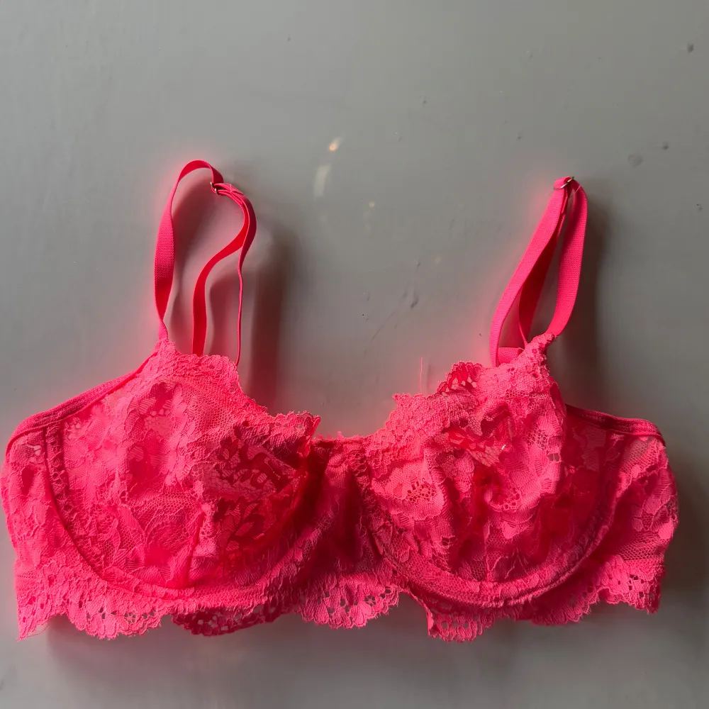 Säljer en snygg rosa spets-bh med justerbara axelband och hakknäppning bak. Den har en vacker spetsdesign. . Muu.