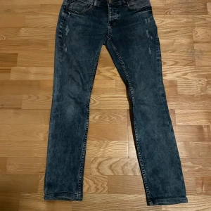 Philipp Plein jeans med dödskalleknapp - Snygga Philipp Plein jeans i en mörkblå tvätt med straight cut. De har en unik dödskalleknappdetalj vid fickan som ger en cool touch. Perfekta för dig som vill ha något annorlunda i garderoben.
