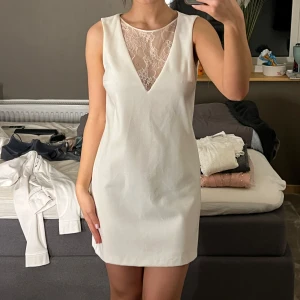 Studentklänning  - Säljer en stilren vit klänning med en spetsdetalj vid halsen som är vringad. Klänningen är alldrig använd och köptes för nått år sen. Passar perfekt till mera formella event eller till studenten☺️säljer då den är för stor för mig.