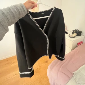Svart kappa från Gina Tricot - Jättesnygg svart kappa med vita detaljer som är i jättebra skick. L i storlek men passar som en M, långa armar.🩷🩷 