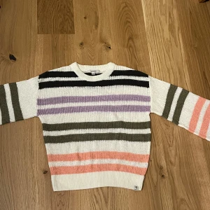Stickad Garcia tröja - En stickad Garcia tröja med färgerna vit, svart, lila, rosa och grön. Har inte använts mer än en gång och är i storlek 164-170.