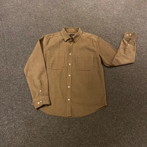 Brun manchester skjorta - Tvärfet camel färgad manchester skjorta som är helt oanvänd. Den är relaxed fit. Om ni har några frågor är det bara att hojta till.😁