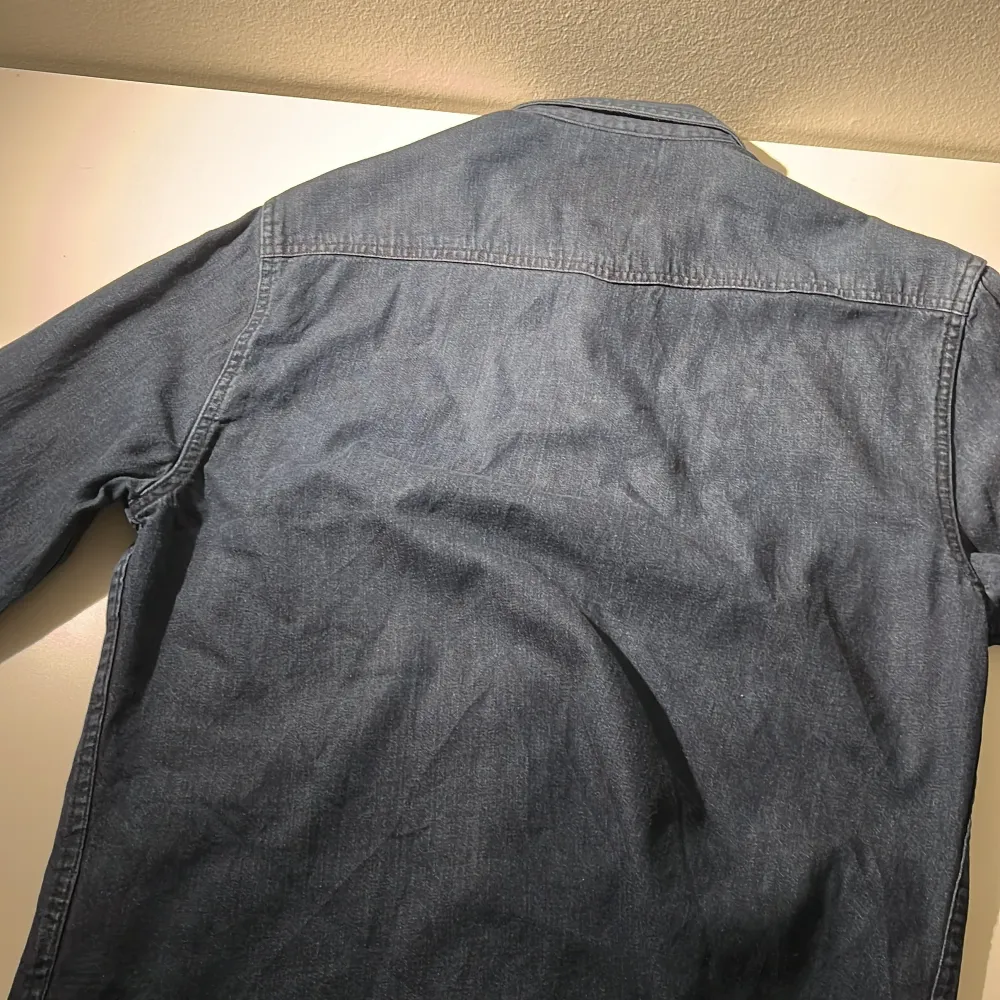 Snygg blå skjorta från Only & Sons i slim fit. Skjortan har långa ärmar och två bröstfickor med knappar. Perfekt för en avslappnad stil med en touch av klassisk denimkänsla.. Paidat.