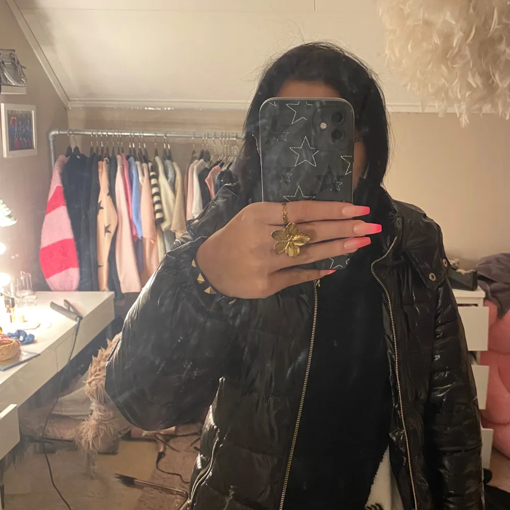 Säljer en svart pufferjacka från Nelly med glansigt material och dragkedja framtill. Jackan har en huva och långa ärmar, perfekt för kyligare dagar. Använt ett antal gånger, så i ett bra/okej skick. Kan finnas några små skavanker men absolut inget man tänker på. Köpte den på plick av en annan tjej, visste inget om att det fanns skavanker från när hon använt den. Passar mig som har storlek XS/S. . Takit.