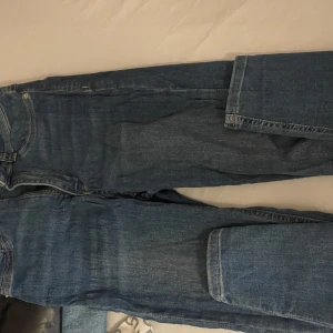 Blå jeans med fickor - Snygga blå jeans med klassisk design och praktiska fickor. Perfekta för en avslappnad stil. De har en dragkedja och knapp framtill.stretch material 