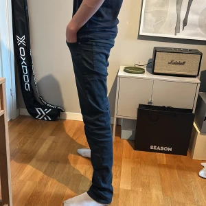 Svarta jeans från Replay Hyperflex - Mörk blå replay jeans i ny skick endast använda ett par gånger (fick dem i julklapp) superstrech varianten i slim fit modell. Dem kostar 1,800 kr ordinarie. Dem är dock köpta för 1,300 kr. Är det några frågor så är det bara att ställa. (Pris ej hugget i sten om det skulle vara en snabb och smidig affär)  RIKTIGT RIKTIGT BRA SKICK. Storlek är 28 W och 32 i L. Jag som har på mig den på bilden är 170 cm, skulle kunna passa båda lite kortare och längre
