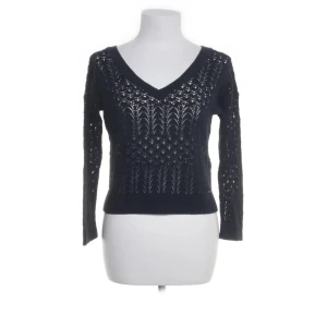 Svart stickad tröja från Hollister - Säljer en snygg svart stickad tröja från Hollister med ett hålmönster. Tröjan har en v-ringad hals och långa ärmar, passar till att bara ha för sig själv eller med något under. 