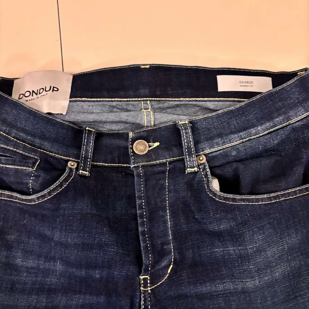 Snygga mörkblå jeans från Dondup med klassisk femficksdesign och kontrasterande sömmar. De har en knappgylf och bälteshällor för extra stil och funktionalitet. Inga skambud tack.. Farkut & Housut.