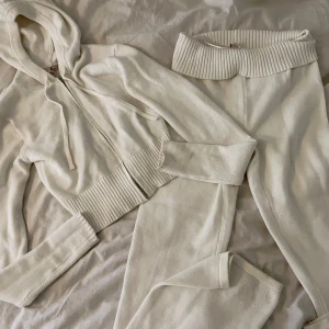 Vit stickad hoodie och byxor - Säljer ett set med en vit stickad hoodie och matchande byxor. Hoodien är croppad med dragkedja och långa ärmar. Byxorna har en ribbad midja för extra komfort. Perfekt för en avslappnad stil. I väldigt bra skick! Strl M i toppen och L i byxorna 💗