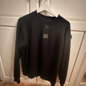 Svart sweatshirt från Hugo Boss - Snygg svart tröja ifrån boss, clean med skön eblem p bröstet, knappast andvönd pris kan diskuteras 