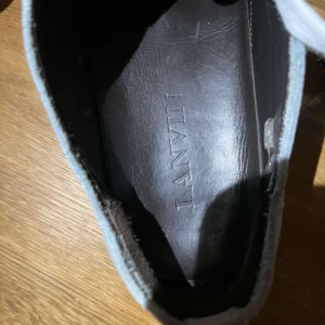 Grå sneakers från Lanvin - Snygga grå sneakers från Lanvin med vit sula och klassisk snörning. Skorna har en stilren design med en diskret logotyp på sulan. Perfekta för en avslappnad och trendig look.