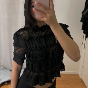 Svart blus - Svart blus med spets och volanger. Perfekt för fest och vardag🩷 Använd några gånger