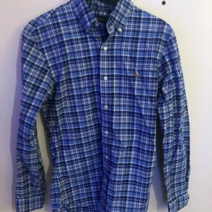 Ralph lauren skjorta stl S - Fräsch och snygg blå rutig Ralph lauren skjorta i stl S. Perfekt skick och inga skavanker. Snygg blå colour combo. Hör av er vid frågor eller funderingar!
