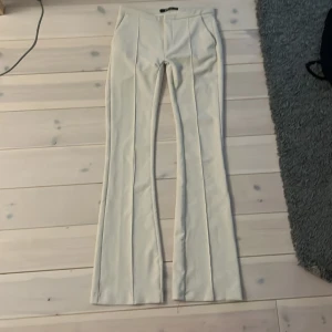 Beige byxor från Gina Tricot - Hej säljer ett par kostymbyxor från Gina dom är omsydda till lågmidjade och xs. Dom har ett hål i skrevet men det är bara på ett lager inte hela vägen igenom. Fråga vid funderingar (innerben:85cm)