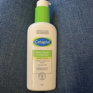 Cetaphil Daily Facial Moisturizer - Cetaphil Daily Facial Moisturizer är perfekt för normal till fet hud. Den återfuktar, skyddar och jämnar ut huden med glycerin och vitamin E. Innehåller låg UVA/UVB-skydd. Flaskan är vit med en grön pump och rymmer 118 ml. Använd fåtal gånger då den inte passade min hud❤️