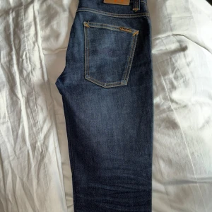 Nudie Jeans Grim Tim  - Modell: Grim tim Storlek: 32/32 Är i helt nytt skick då de är oanvända, inga defekter, perfekta jeans till höst/vinter Nypris ca 1600kr, om du har övriga frågar så kan du bara skriva