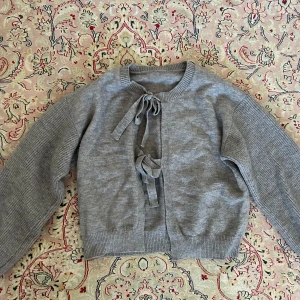 Kofta / tjocktröja - Mysig kofta med två rosetter fram