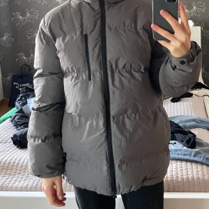Grå dunjacka - Oversized grå dunjacka från H&M. Den är endast använd förra vintern därav väldigt bra skick. Väldigt varm och har även resår vid jackans slut så du kan stänga inne värmen. 