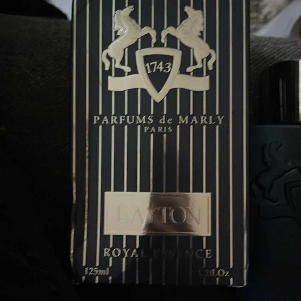 KOM PRIVAT FÖR MER INFO. Säljer en lyxig parfym från Parfums de Marly, modellen Layton. Flaskan är elegant i mörkblått med en stilren design och silverfärgad kork. Doften är en Eau de Parfum och kommer i en förpackning på 125 ml. Perfekt för den som vill ha en sofistikerad och tidlös doft.. Parfym.