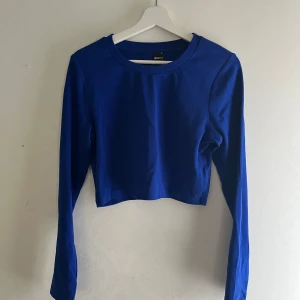 Blå crop topp - En mörkblå crop topp med långa armar, använd bara en gång så är som ny. Stretchig så den passar flera storlekar, perfekt för vanlig användning eller kanske till halloween som tex snövit 🍎