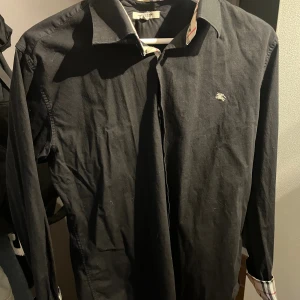 Burberry skjorta  - Säljer denna burberry skjortan då den inte passar mig. Den är inte äkta! Det står att den är L men skulle säga att den passar mer till S