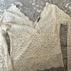 Vit spetsblus från zara - Säljer en superfin vit spetsblus från zara. Den har en v-ringad design och långa ärmar. Perfekt för både vardag och fest! 💫storlek M passar S!