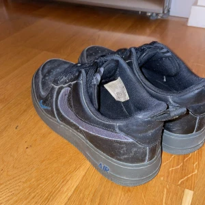 Nike Air Force 1 svarta med blåa detaljer  - Nike Air Force 1 dom är i bra skick men skulle bara behöva tvätta dom och så är det märken i skon, storlek 42 kan diskuteras om pris