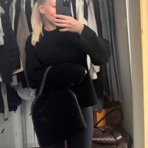 Väska  - En svart väska med mörk silvrig kedja. Går att ha den i armvecket men även på axeln. Väldigt rymlig och bra skick!!! Köptes för 400 men minns inte från vilket märke…