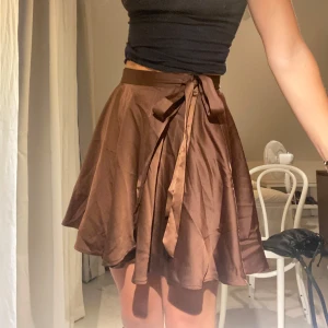 Brun omlottkjol - Brun glansig omlottkjol man knyter själv precis så man vill ha den. Därför skulle jag anse att de passar allt från Xs-L. Använd bara någon enstaka gång. 