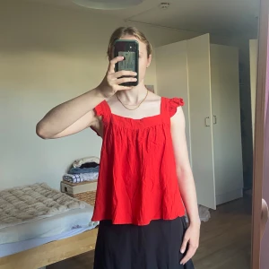 Röd kortärmad sommarblus  - En fin klarröd sommartopp från H&M som knyts med en rosett i ryggen. Tyvärr har den inte alla lappar kvar, men storlek skulle jag säga är S/M. Den är i superfint skick!