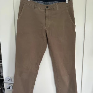 Chinos från Sunwill  - Grå beige chinos från Sunwill i modellen slim. Storlek: se bild (Uk 30) Inga defekter, använda ett fåtal gånger. Är som i ny skick. 