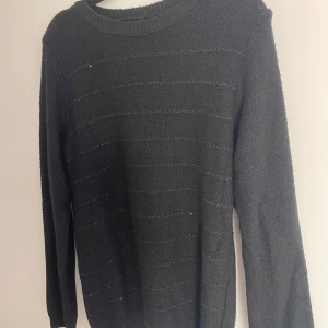 Svart stickad tröja med glitterdetalj - Säljer denna supersnygga Stockholmsstil tröja! Perfekt till vintern! Tröjan är endast andvänd ett fåtal gånger och därför i god skick! Styla med ett par korta jeans shorts och boots!🤩🤩