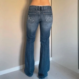 Low waist jeans - Ett par jättefina lågmidjade utsvängda jeans. Säljer då de inte kommer till användning💕obs!ett litet ihopsytt hål över ena fickan, se bild 3