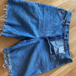Levis shorts - Blå levisshorts köpa second hand. Står inte storlek men passar en 36/38 beroende på hur en vill de ska sitta. Midjemått 39