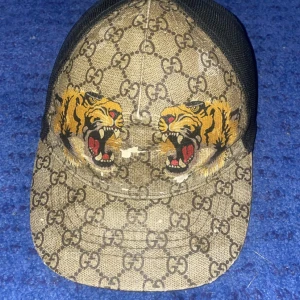 Tiger Gucci keps  - Tjena jag säljer eller byter för något annat nu min Gucci keps för att den inte passar mig längre och vill gärna byta min still. Lite skadad på framsidan men inget farligt ,Pris går att diskutera 