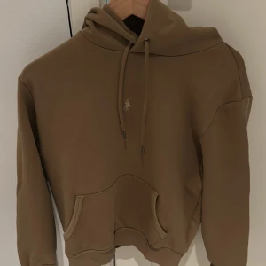 Beige hoodie från Polo Ralph Lauren - Säljer en hoodie från Polo Ralph Lauren. Perfekt för höst och vinter. Den har blivid använd ca 10 ggr. Nypris:1700