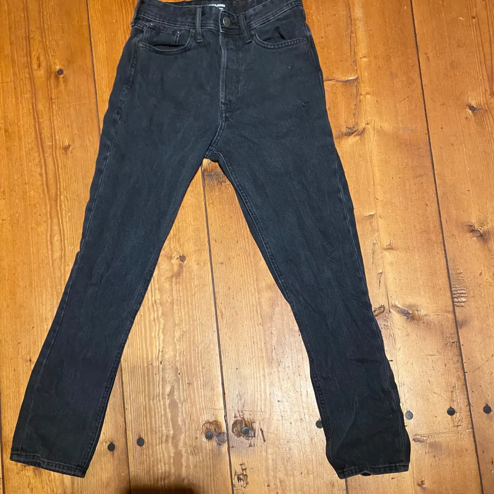 Säljer ett par svarta jeans från Jack and Jones i storlek 28/32. De har en klassisk design med fem fickor och en knappgylf. . Jeans & Byxor.