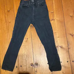 Säljer ett par svarta jeans från Jack and Jones i storlek 28/32. De har en klassisk design med fem fickor och en knappgylf. 