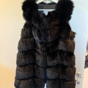 Pälsväst - Svart pälsväst från Lovely of Sweden i storlek L. Skulle säga att den passar M eller liten L.  Nyskick! 