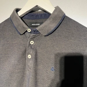 Jack & Jones pike - Säljer en pikétröja från Jack & Jones i storlek small.  Använd utan defekter. Svårt att beskriva färgen men skulle säga någon blandning av blå, grön och grå.