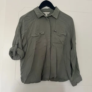 Skjorta - Fin och hel. Som bilden visar kan man välja om man vill ha ärmarna uppkavlade eller inte.