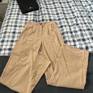 Kostymbyxor beiga  - Beiga kostymbyxor från bershka, knappt använda. Lite utsvänga ben