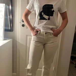 Low waisted jeans, créme vita - Lågmidjade jeans i modellen ”Arrow” från Weekday. Storlek W28 L34 Små fläckar längst nere på innerbenet/vid fötterna. Inget man lägger märke till.