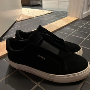 Svarta sneakers från Axel Arigato - Säljer ett par stilrena svarta sneakers från Axel Arigato i bra skick. Skorna har en klassisk design med vit sula och är perfekta för både vardag och fest. De är bekväma och passar till det mesta i garderoben. Perfekt för dig som vill ha en snygg och mångsidig sko! 🖤använda halva förra hösten men inga synliga defekter. Mocka 