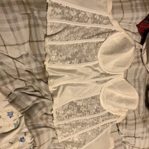 Korset  - En vit korset med spännen där bak. Ca storlek 40-44. Använd ändats en gång. Säljer pga för stor. Köpt för 400kr secondhand. Pris kan diskuteras.