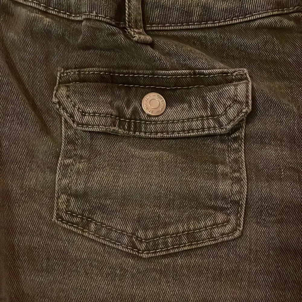 Säljer ett par grå jeans från Gina Tricot i storlek 170. De har en klassisk femficksdesign med knapp och dragkedja framtill. Byxorna har en rak passform och är perfekta för vardagsbruk. Materialet är slitstarkt och bekvämt, vilket gör dem till ett bra val för både skola och fritid.. Jeans & Byxor.