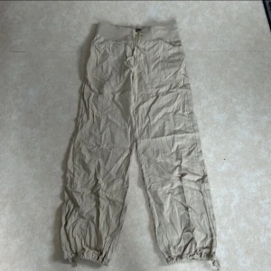 Beige byxor från ONLY - Säljer ett par beige byxor från ONLY i storlek 38. Byxorna har en loose passform med resår i midjan och vid bensluten för extra komfort. Perfekta för en avslappnad stil och kan enkelt matchas med olika toppar. Materialet känns lätt och luftigt, vilket gör dem idealiska för vår och sommar.