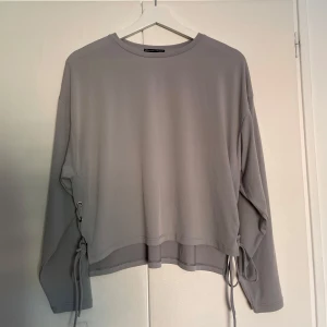 Tröja - Säljer denna tröja från Zara i grå färg med knyt på sidorna🌟 Skriv om du har frågor!
