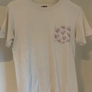 Kaws Pocket Tee - Vit Kaws x Uniqlo pocket tee i storlek XS. Tveka inte på att skriva om ni har några frågor!