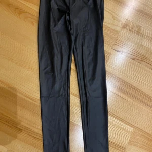 Svarta leggings från Rainbow - Snygga svarta leggings från Rainbow i storlek XS. De är tighta och har en glansig finish som ger en cool look. Perfekta för både vardag och fest! 🖤